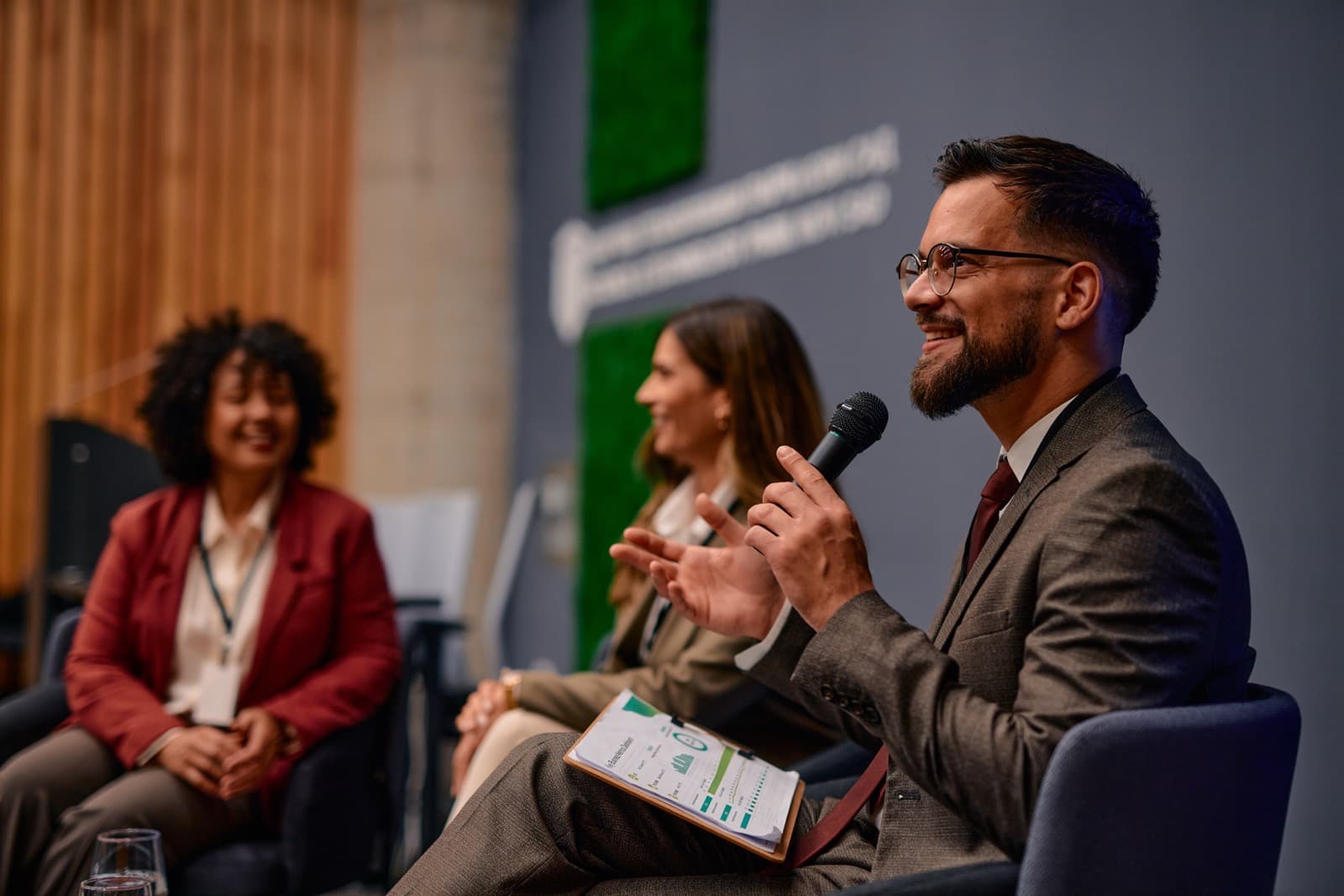 Panelists speaking before an audience at a policy discussion